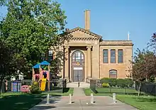 Blond brick building with playground equipment