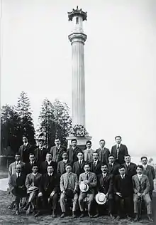 Formal picture of 24 Japanese-Canadian men in suits, seated and standing before the Japanese Canadian War Memorial, c. 1920