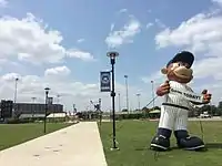  Walkway leading to Four Winds Field at Coveleski Stadium, pictured in July 2015. There is an inflatable display of the South Bend Cubs mascot, Stu, holding a sign advertising a game to be played that day.