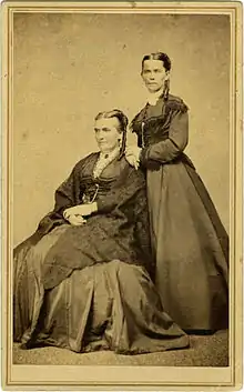 Two women—the older one seated and the younger one standing