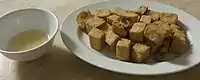 A dish of fried tofu  (炸豆腐) with dipping sauce.