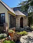 Front door framed by large stones and a turret