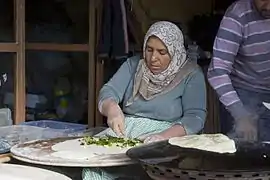 Gözleme, a filled bread, being baked on a sac