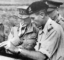 Three officers facing to the left looking at a document / map