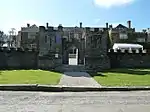 Entrance gate and flanking walls forming mock fortifications to east of Prideaux Place