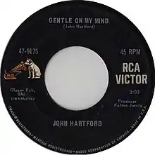 Black RCA Records 7-inch single label. On the left side, a drawing of a dog staring into a gramophone is seen. On the Right side, a text reads RCA Victor. The top reads Gentle on My Mind (John Hartford). The bottom reads John Hartford.