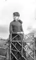 Girl holding a fan behind a wooden gate