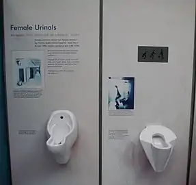 Two different designs of wall-mounted female urinals at an exhibition