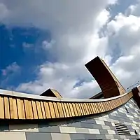 The curved roof line features a grass roof to minimise the building's carbon footprint.