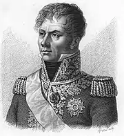 Black and white print of a wavy-haired man with a stern look and long sideburns. He wears a dark military coat of the Napoleonic era adorned on the lapels and high collar with generous amounts of lace.