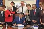 Photo of a man signing a document