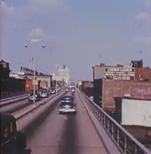 An elevated four lane freeway in an urban area as it appeared in 1954