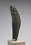 Left greave of a Greek Hoplite. This example has elaborate decoration in repoussé (a technique in which metal is impressed from the rear to form a raised design), including a lion's face over the knee and lines emphasizing the calf muscles. Tiny holes lining the top and bottom edges secured a fabric lining and leather straps.