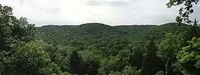 A photo of the forested hills and valley viewed from an overlook.