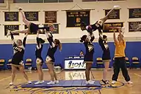 Gymnastics formation by cheerleaders at school in United States.