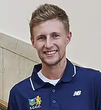 Headshot of Joe Root in a blue polo shirt.