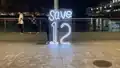 'Save 12' neon signage at the entrance of Harbour City