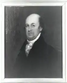 A bald man in a white shirt and tie and black jacket