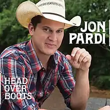 The cover features a man wearing a plaid shirt and cowboy hat, sitting on a picnic table in a forest park, with his left elbow resting on it.