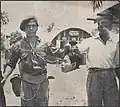 Commonwealth soldiers pose with a decapitated head inside a British military base in Malaya during the Malayan Emergency