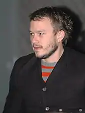 Young man with short beard, looking past the camera