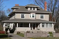 Two-story house with extensive porch, dormers, brick chimneys