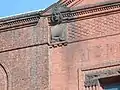 Medallion with man's head and the first two digits of year built -"18". Note the basket weave design of the brick pattern.