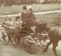 Charles Edward and Wilhelm II sat in the back of a horse-drawn carriage which is being driven by two other men sat in the front