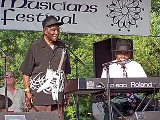 The two musicians onstage: Edwards standing and Perkins seated at a keyboard