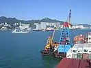 At anchor, two barges with cranes (floating derricks) at port