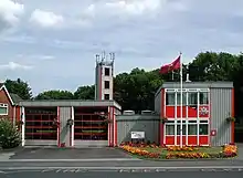 A grey and red, very angular and clean looking prefabricated building of two bays.