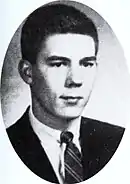 Oval-shaped photo portrait of a young man with short hair wearing a suit