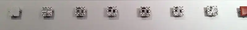 Steps in manufacturing Solid Logic Technology hybrid modules. The process starts with a blank ceramic wafer, 1⁄2 inch (13 mm) square. Circuits are laid down first, followed by resistive material. Pins are added, the circuits are soldered and the resistors trimmed to the desired value. Then individual transistors and diodes are added and the package is encapsulated.