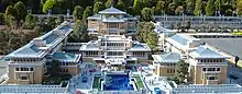 A photograph of a scaled down model of a hotel with two building wings either side of a main building with a fountain in front