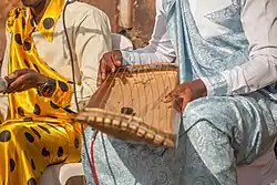 Photo of a trough zither called an Inanga, and its player Torobeka Joseph from Burundi.