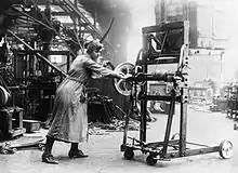 A female worker demonstrates a machine which can lift boxes to save physical labour at the Bowling Iron Works, Bradford, in November 1918