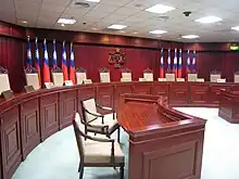 Interior view of a court room with the Scales of Justice embossed in the far wall