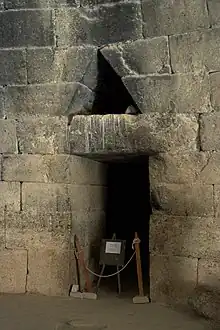 Photograph of a small door within a dark chamber.