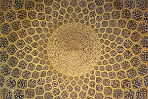 The interior of the dome which is inset with a network of lemon-shaped compartments, which increase in size as they descend from a formalised peacock at the pattern inlaid on plain stucco