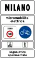 Town sign: start of urban area where electric micromobility is being experimented (50 km/h speed limit, no use of horn and particular caution to cyclists and motorized scooters)