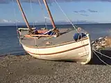 The replica of James Caird to the Strait of Magellan, with in the background the Tierra del Fuego.