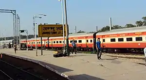 Long orange-and-white passenger train in a station