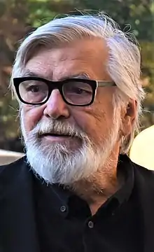 White-bearded Jiří Bartoška wearing glasses, looking right of camera