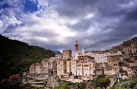 A town on a slope of a hill with houses and minarets