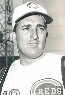 A man in a light baseball uniform with a "C" on the center of his cap