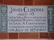 A tablet formed of six standard sized tiles, bordered by green flowers in the style of the Arts and Crafts movement