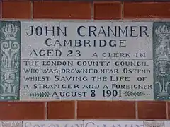 A tablet formed of six standard sized tiles, bordered by green flowers in the style of the Arts and Crafts movement