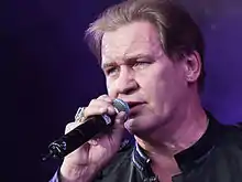 Close-up photo of Johnny Logan performing on stage in 2010.