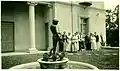 A small group of women and men view the sculpture, c. 1920