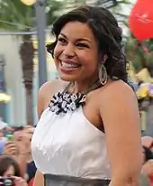 A picture of a woman smiling wearing a white dress